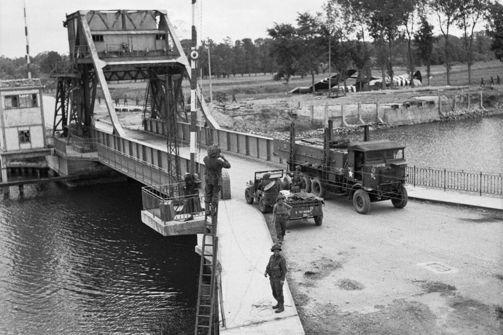 The all-important Pegasus Bridge in June 1944. Crashed Horsa gliders in the field behind - expert flying to get so close! Photo: Sgt Christie, Army Photo Unit