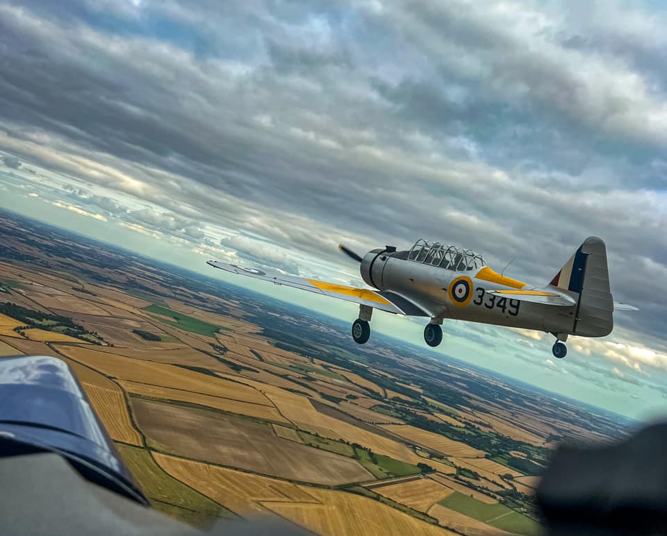 Sean Link sitting on the wing of a Yale en route to Duxford.