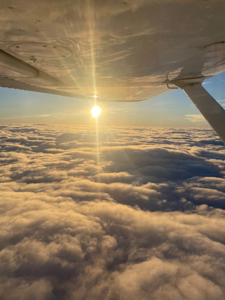 Clouds beneath a light aircraft wing.