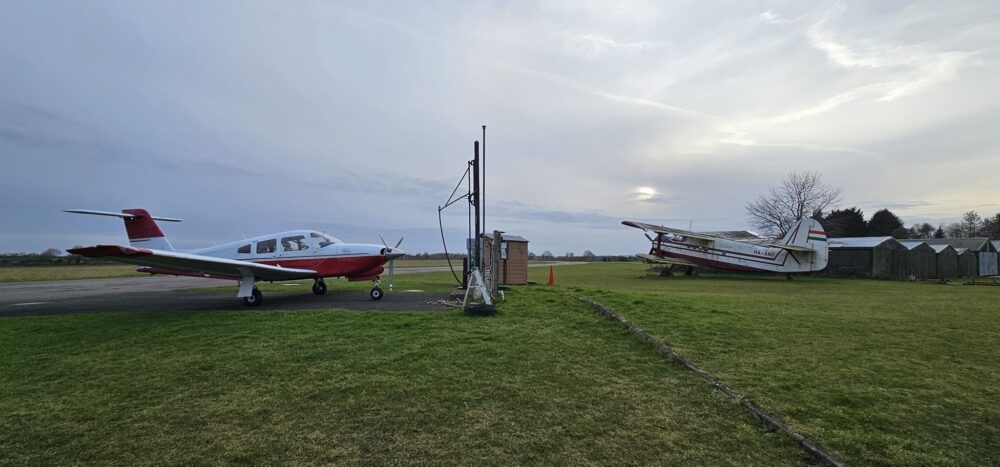 Two light aircraft parked on grass.