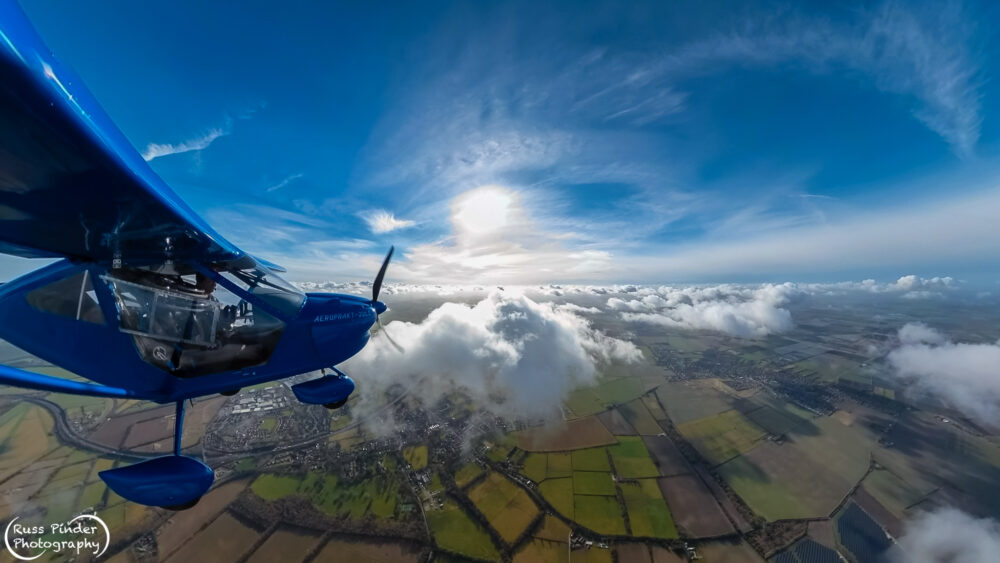 Aerial photo of light aircraft over landscape.