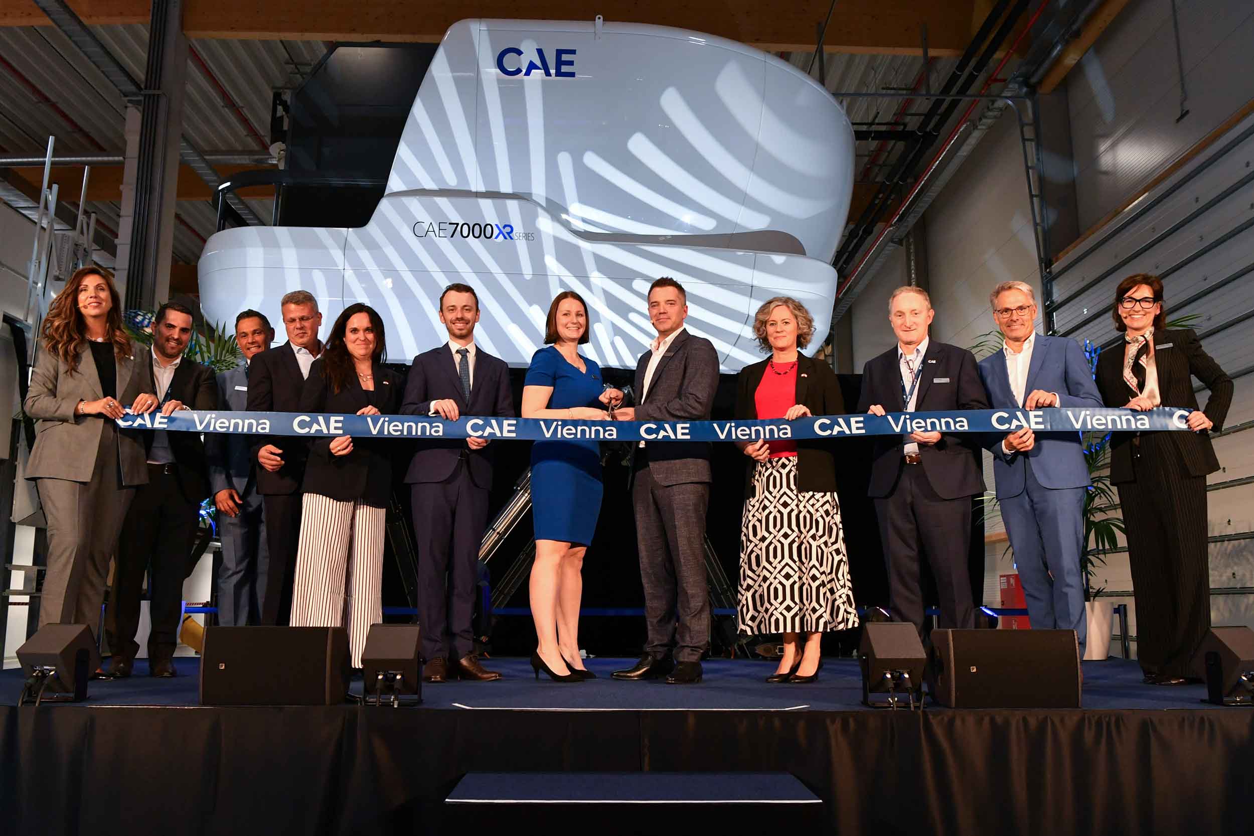 CAE's Vienna team in front of a full flight simulator. Photo: CAE