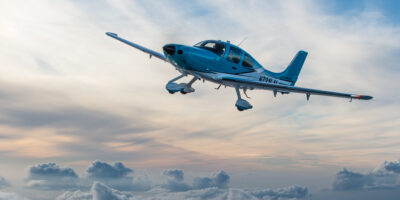 A Cirrus Aircraft SR22T flies amongst a cloudscape