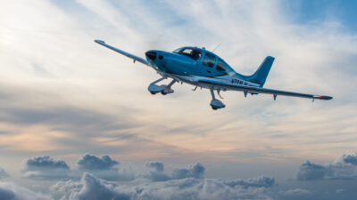 A Cirrus Aircraft SR22T flies amongst a cloudscape