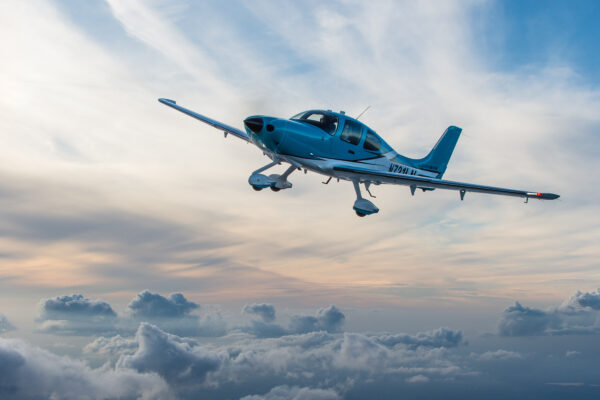 A Cirrus Aircraft SR22T flies amongst a cloudscape