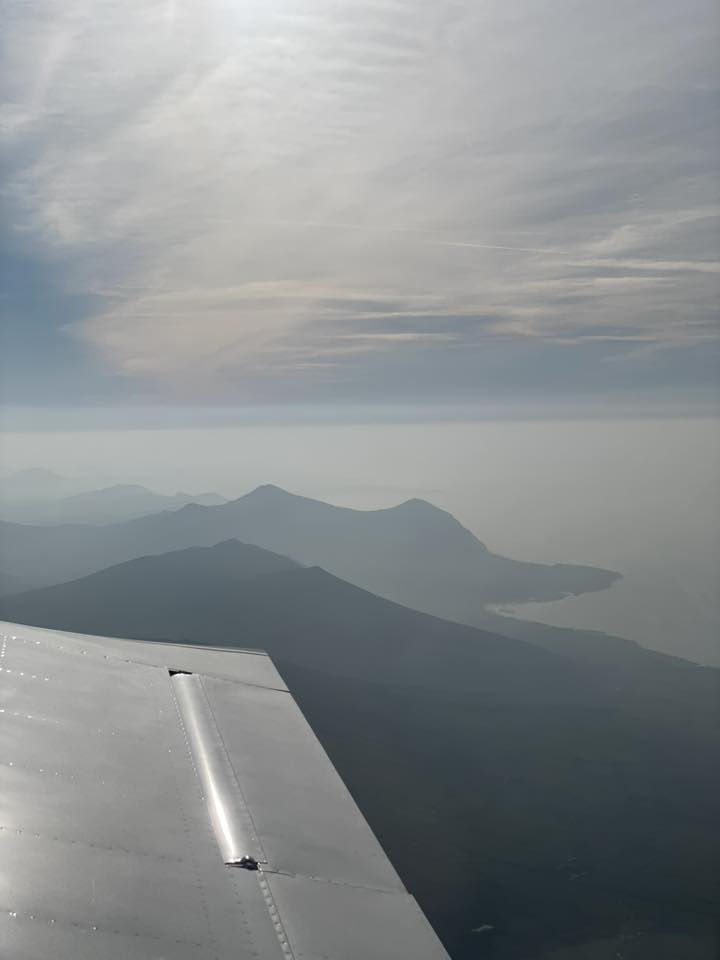 Light aircraft wing and distant mountains.