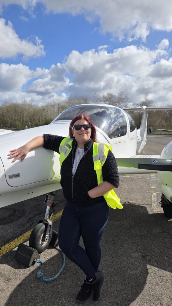 Woman stood by aircraft.