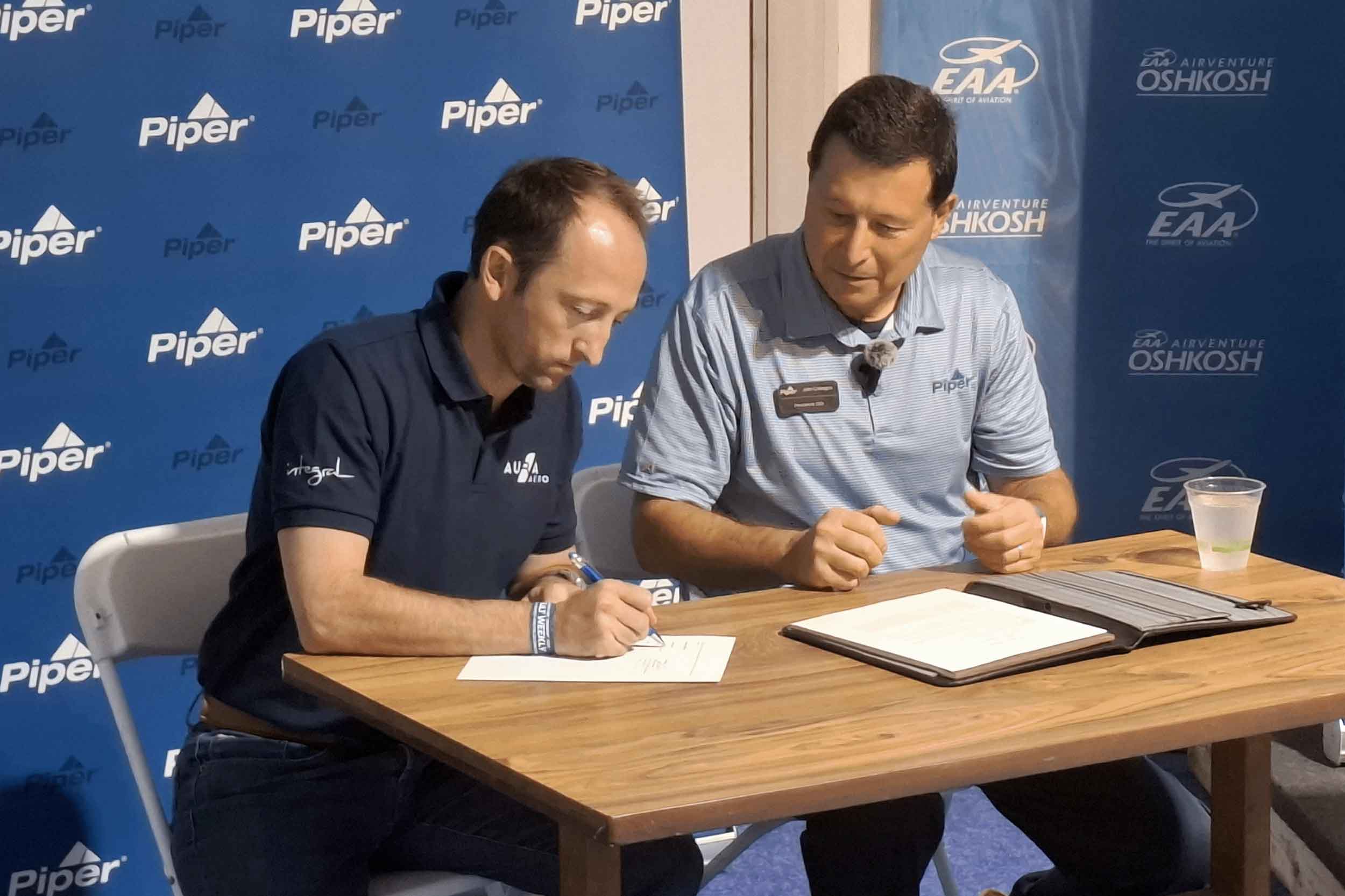 Piper's John Calcagno, right, signing the MoU with Aura Aero's Jérémy Caussade at Oshkosh